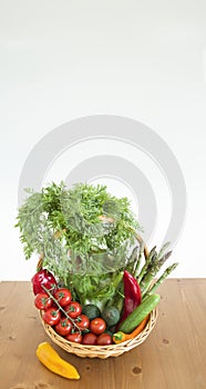 fresh assorted Vegetables in basket on wooden table,consumer vegetarian basket, tomatoes, fennel, paprika, asparagus