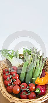 fresh assorted Vegetables in basket on wooden table,consumer vegetarian basket, tomatoes, fennel, paprika, asparagus