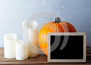 Fresh Autumn pumpkin and candles with menu blackboard