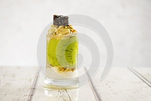 Fresh avocado cocktail with cream, honey and almonds  on a grungy wooden table
