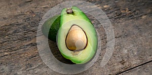 Fresh Avocado cut in half on wooden board background