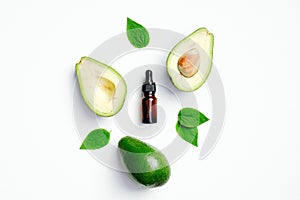 Fresh avocado and essential oil bottle on white background. Flat lay, top view. SPA natural organic cosmetics, eco beauty product