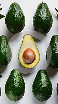 Fresh avocado and green leaves arranged on a white background