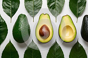 Fresh avocado and green leaves arranged on a white background