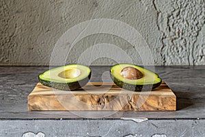 Fresh avocado halves on a wooden cutting board