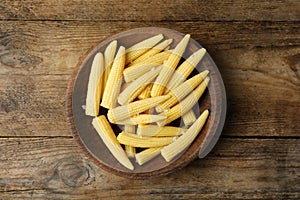 Fresh baby corn cobs on wooden table, top view