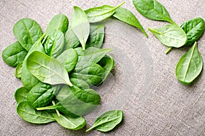 Fresh Baby spinach leaves on sackcloth background. Top view with copy space. Healthy, Ecology concept