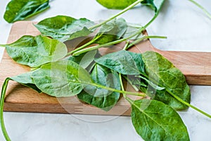 Fresh Baby Spinach Leaves on Wooden Board