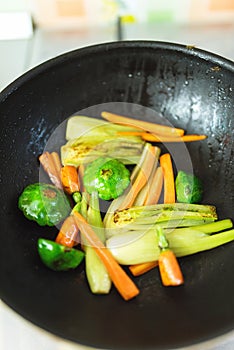 Fresh baby vegetables being sauteed