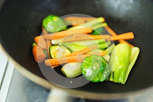 Fresh baby vegetables being sauteed