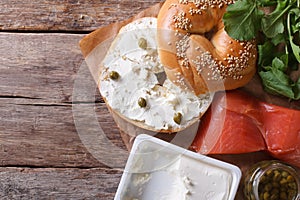 Fresh bagel with cheese, red fish and ingredient top view