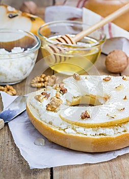 Fresh bagel with cottage cheese, pear, walnut and honey for breakfast