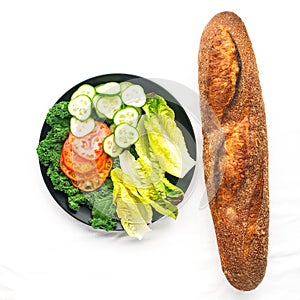 Fresh baguette and vegetable slices, tomatoes, cucumber, romano lettuce leaves, mushrooms for making sandwiches for a