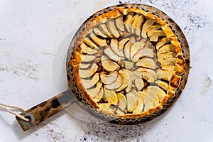 Fresh baked apple pie with fruits on a stone table