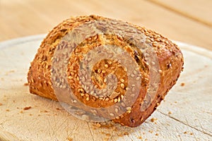Fresh baked bread on a table at a bakery or kitchen. Homemade seeded wheat bun freshly prepared by a nutritionist baking
