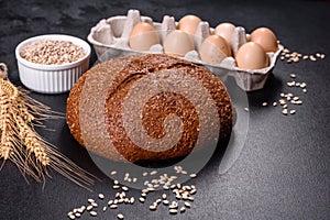 Fresh baked brown bread with ears and grains of wheat