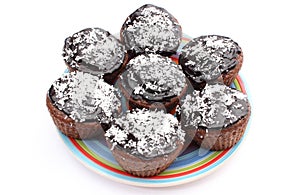 Fresh baked chocolate muffin with desiccated coconut on colorful plate