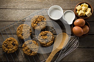 Fresh baked cookies, whisk, eggs, flour on wooden table