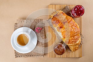Fresh baked croissant with raspberry jam , chocolate and espresso coffee