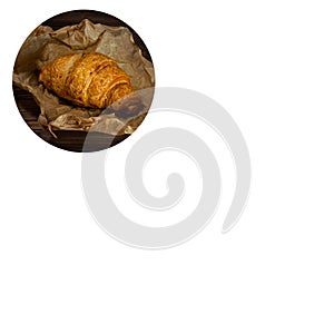 Fresh baked croissant on wrapping paper. copyspace. white background