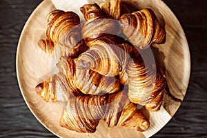 Fresh baked croissants. Warm fragrant butter croissants and rolls on a wooden stand. French and American pastries are popular all