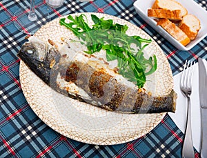 Fresh baked fish sea bass with arugula photo