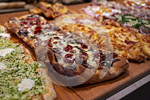 Fresh baked focaccia or pala romana pizza with vegetables and cheese in bakery in Parma, Emilia Romania, Italy close up photo