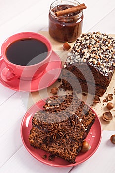 Dark cake with chocolate, cocoa and plum jam, cup of coffee, delicious dessert