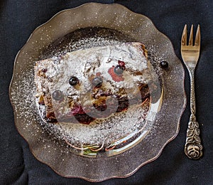 Fresh baked homemade blueberry pie on glass plate on a dark back