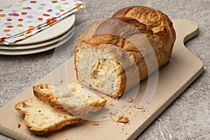 Fresh baked loaf of croissant bread and slices on a cutting board