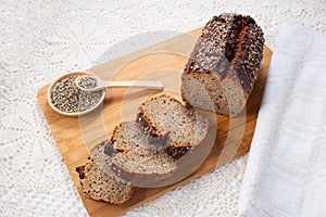 Fresh baked loaf of spelt sourdough bread with hemp seeds is on linen towel. Healthy pastry