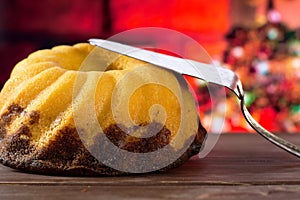Fresh baked marble gugelhupf sweet bread with christmas tree behind