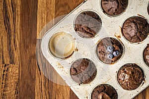 Fresh baked muffins with chocolate cream and blueberries in ceramic pan copy space top view