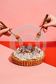 Fresh Baked Pumpkin Pie with Cinnamon Whipped Cream on pink background. Hand with spoon