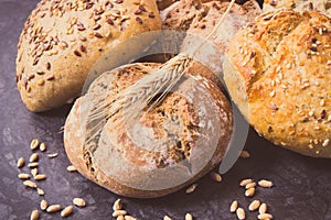 Fresh baked rolls with seeds and ears of rye or wheat grain. Vintage photo