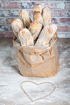 Fresh baked rustic bread loaves in paper bags