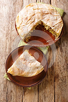 Fresh baked traditional Moroccan Pastilla or chicken bastilla closeup in the plate. Vertical top view