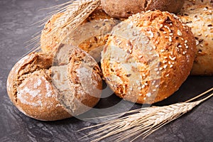 Fresh baked rolls with seeds and ears of rye or wheat grain