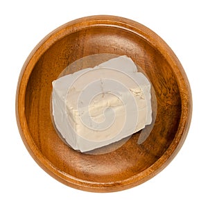 Fresh bakers yeast block, compressed yeast in a wooden bowl