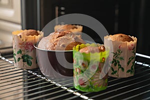 Fresh baking cupcakes with raisins on a baking sheet in the oven