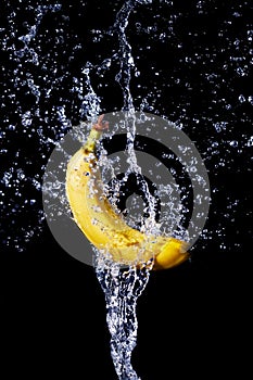 Fresh banana gets hit by a water stream