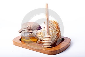 Fresh bee honey in  jar and honeycombs close-up on white background