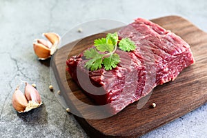 Fresh beef piece for steak or grilled barbecue / Raw meat beef steak with spices garlic on wooden cutting board and black