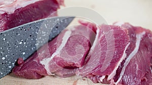 Fresh beef is sliced with sharp ceramic knife.