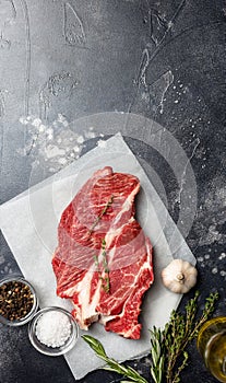 Fresh beef steak on black background with spices. Ready for cooking. Top view with copy space