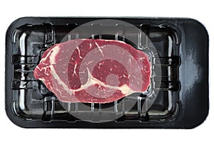 Fresh beef steak in plastic tray on white background.