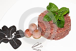 Fresh beef tartar dish with tasty onion and with mint leaves