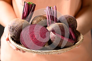 Fresh beetroot in basket holding by woman hand