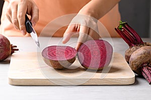 Fresh beetroot on cutting wooden board with hand