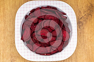 Fresh beetroot pieces arranged in a plastic bowl.